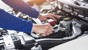 Immagini delle mani di un meccanico che lavorano nel cofano di un auto